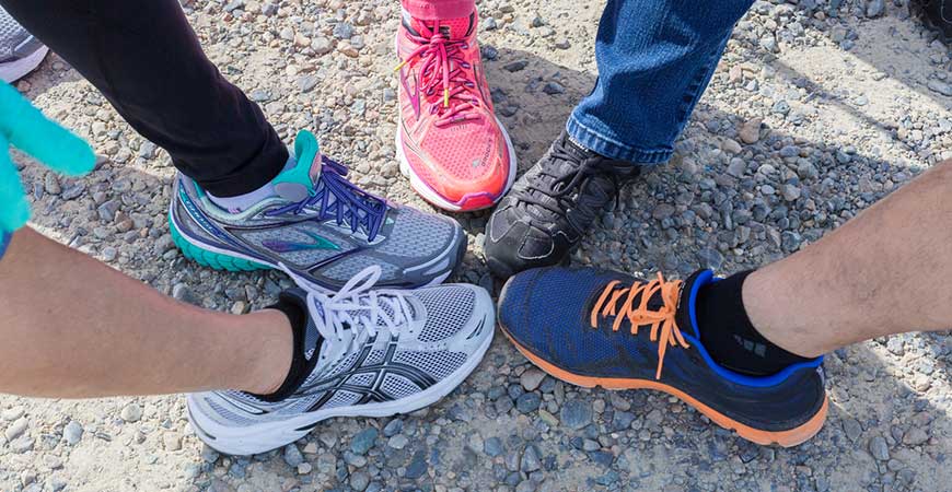 Five tennis-shoe clad feet form a circle.