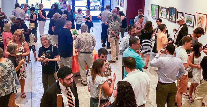 A large group of people mingle in the main room of the Merced Multicultural Arts Center in Merced.