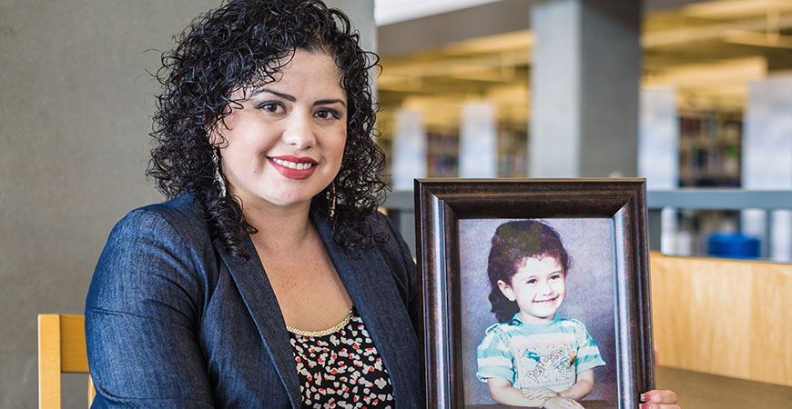 Yazil Navarro holding a photo of herself as a child.