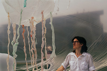 Artist-in-residence Olga Diego stands inside her "jellyfish bowl" exhibit on the UC Merced campus.