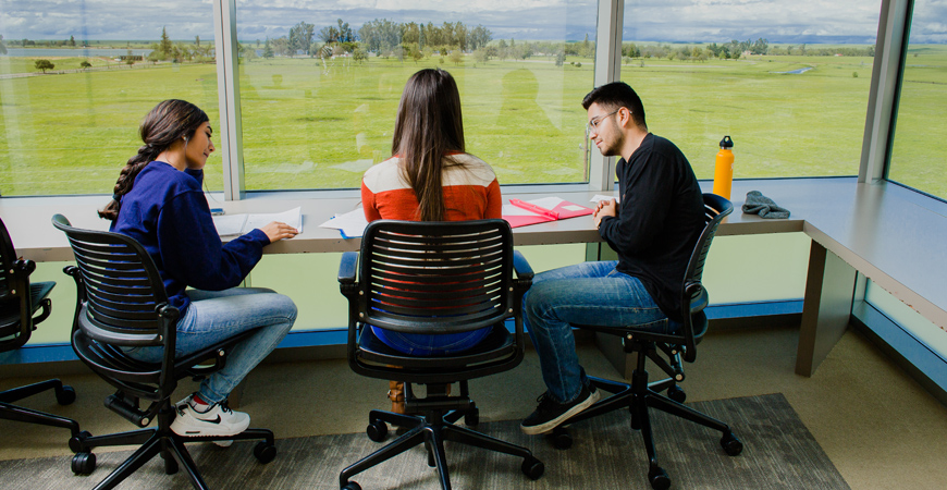 Three students study in Half Dome student housing.