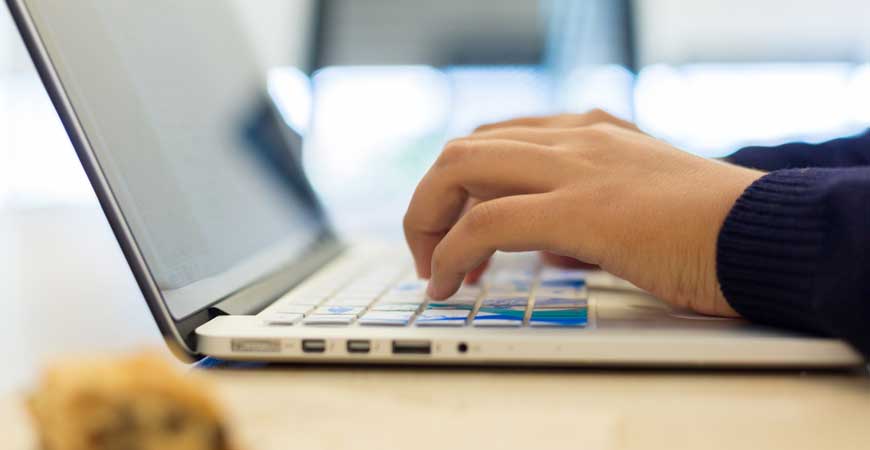 Hands typing on a laptop.